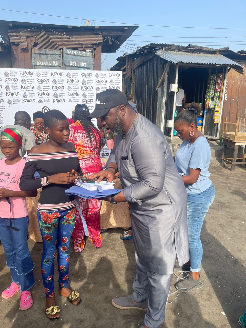 Kajola Foundation volunteer distributing books and uniforms