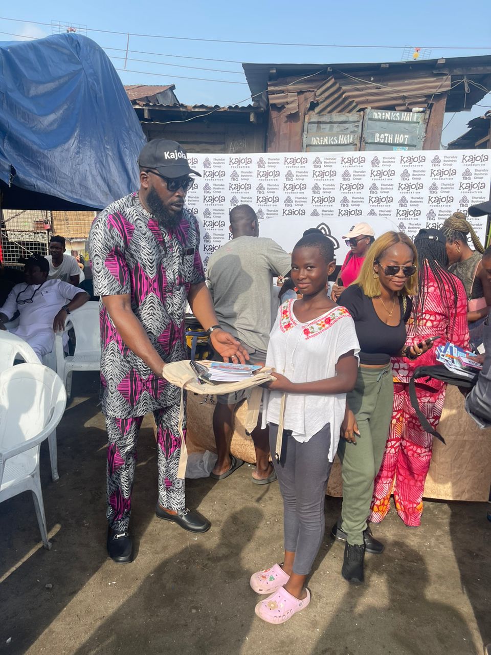 TBG member presenting a school bag to a girl