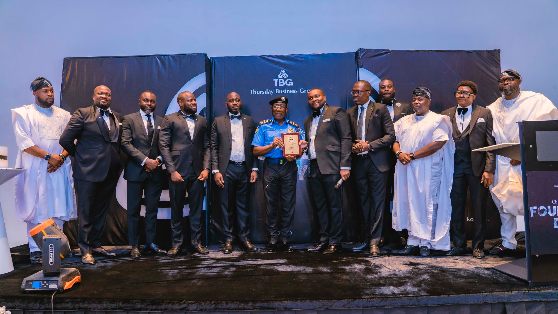 TBG presenting a recognition award on stage