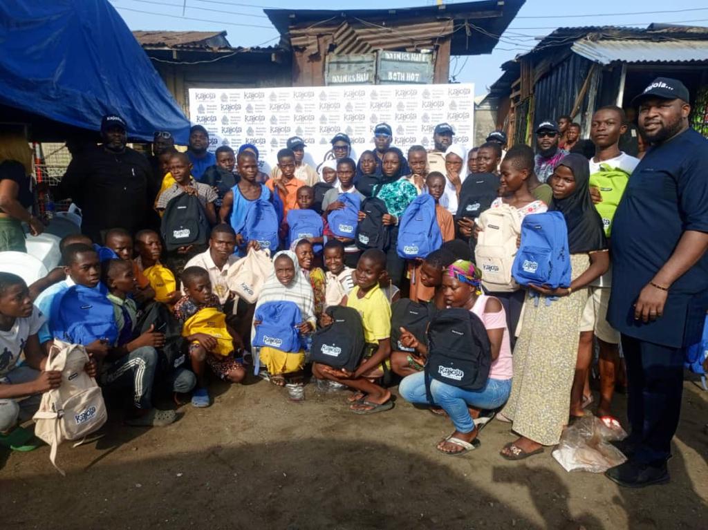 Large group photo of students holding Kajola Foundation backpacks